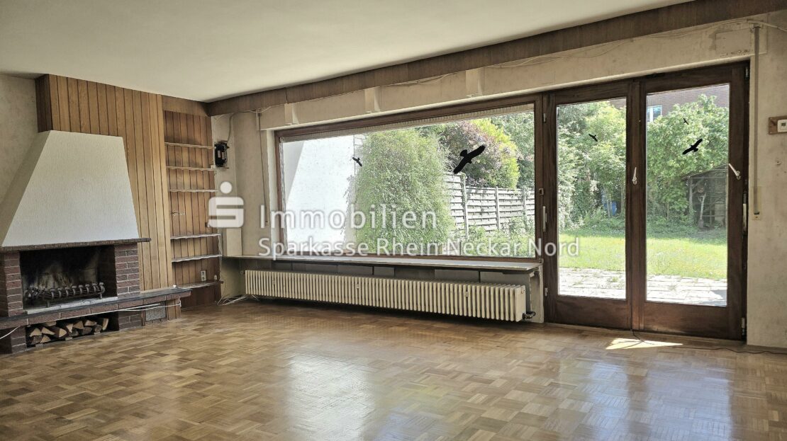 Wohnzimmer mit Blick auf Kamin und Garten