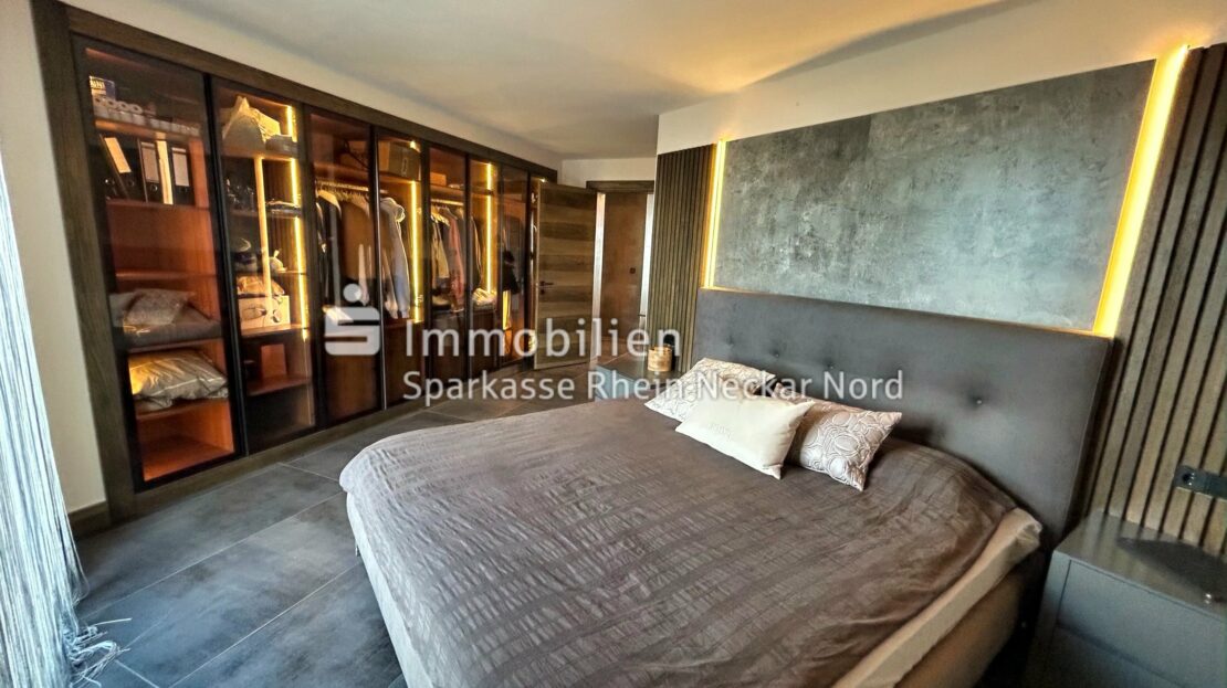 Schlafzimmer mit maßgefertigtem Ankleideschrank und stimmungsvoller Beleuchtung