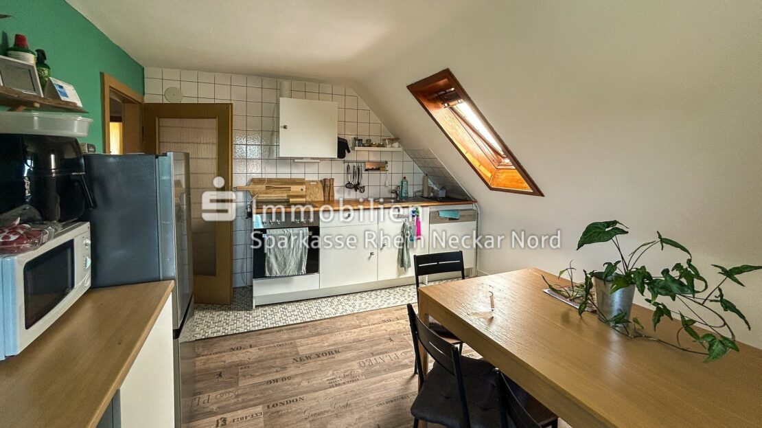 Helle Küche mit Esstisch und Dachfenster