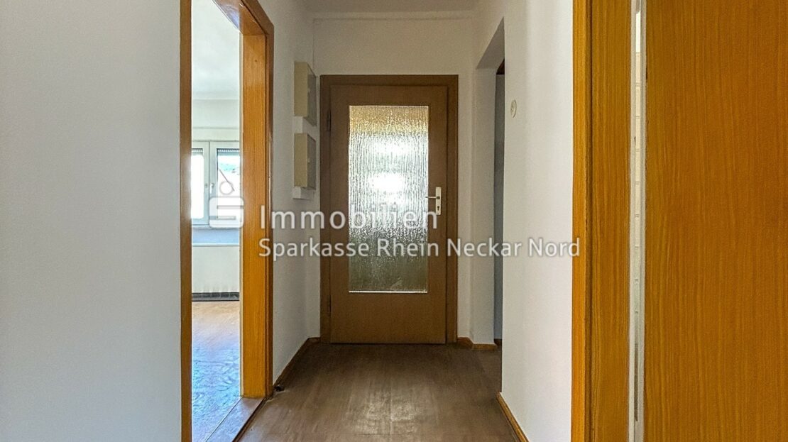 Heller Flur mit Holztüren und Boden in Holzoptik