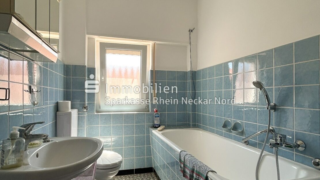 Badezimmer mit blauen Fliesen und Badewanne