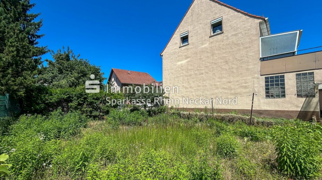 Gartenfläche hinter Wohnhaus mit Wiese