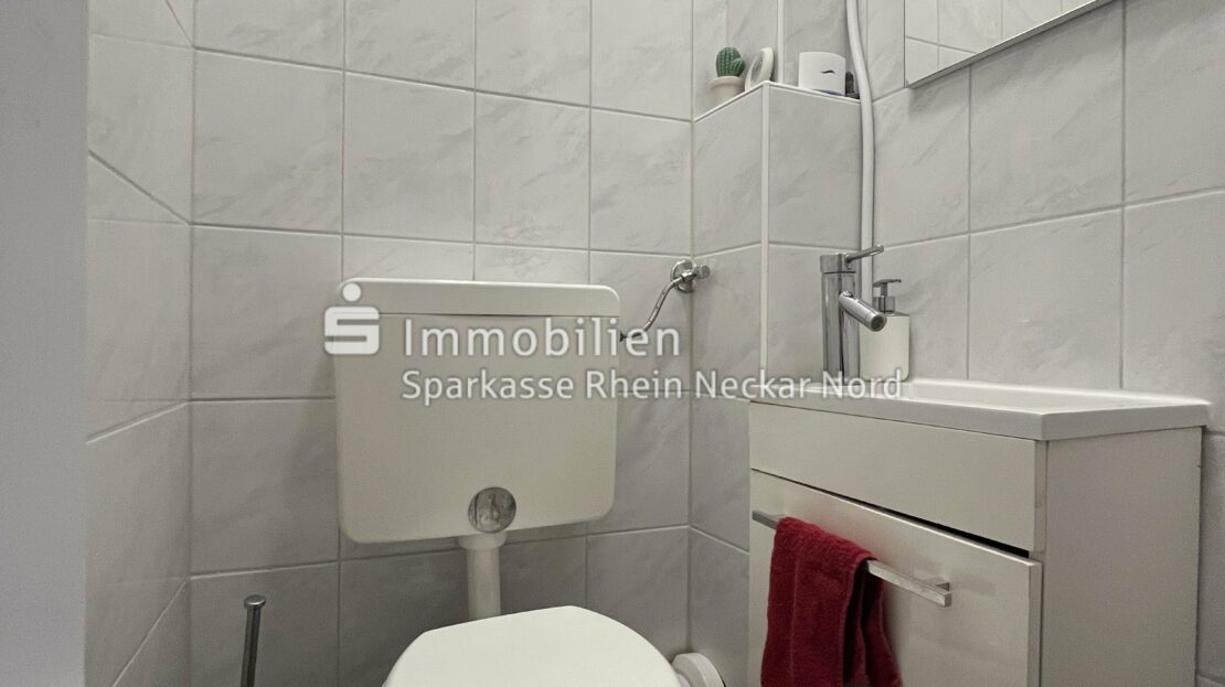 Gäste-WC mit hellen Fliesen und Waschbecken
