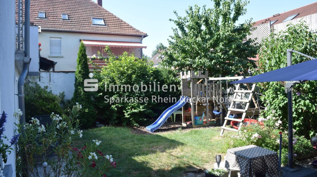 Garten mit grünem Rasen und Rutsche